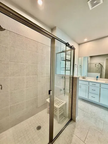a bathroom with a granite countertop bathtub shower sink and mirror