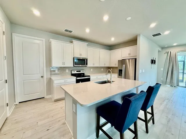 a kitchen with refrigerator cabinets dining table and chairs