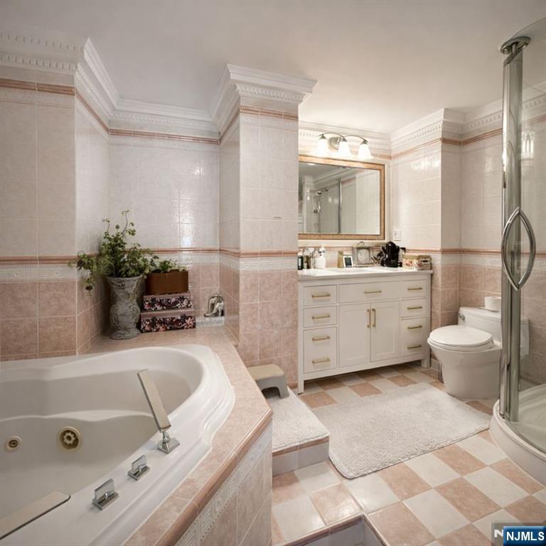 200 Old Palisade Road, Unit 18D Fort Lee, NJ 07024 - Photo 10 of 14 a bathroom with a tub sink toilet and mirror