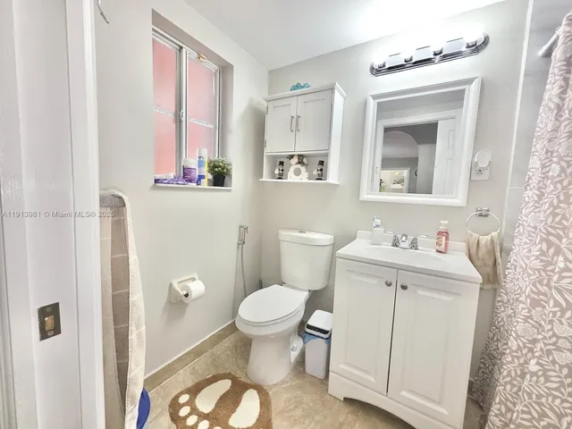 a bathroom with a toilet a sink and a mirror