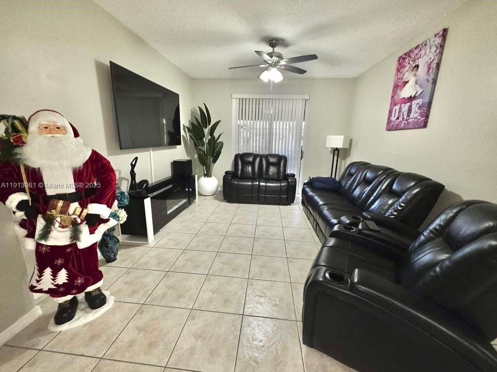15871 Southwest 86th Terrace Miami, FL 33193 - Photo 2 of 30 a living room with furniture and a flat screen tv