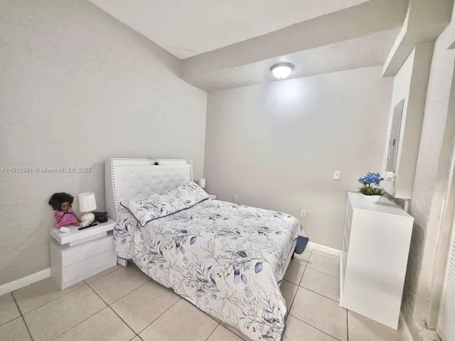 a bedroom with a bed and a potted plant