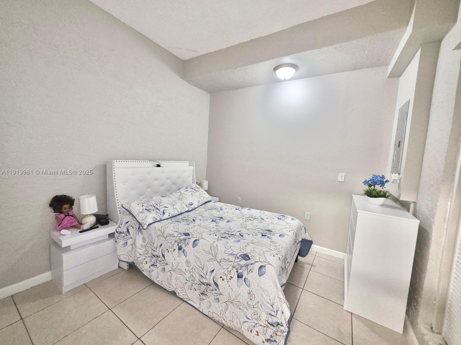 15871 Southwest 86th Terrace Miami, FL 33193 - Photo 9 of 30 a bedroom with a bed and a potted plant