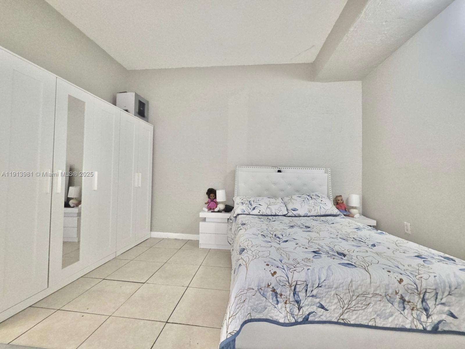 15871 Southwest 86th Terrace Miami, FL 33193 - Photo 10 of 30 a bedroom with a bed and a refrigerator