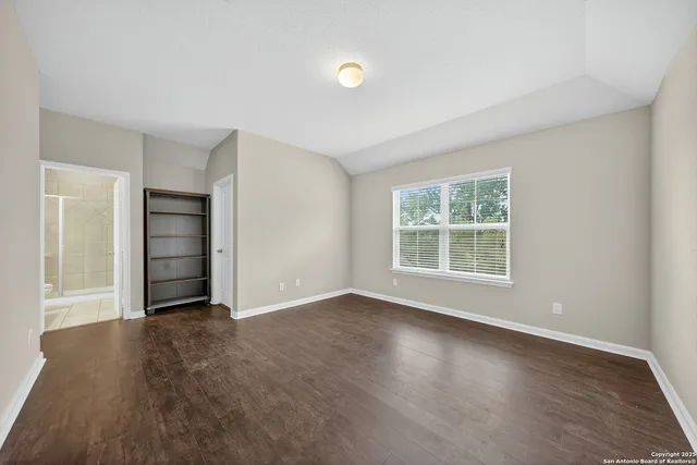 an empty room with closet and windows