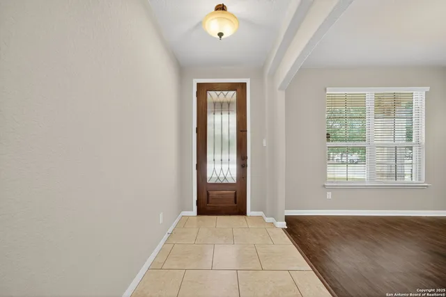 a view of an empty room with window and bathroom