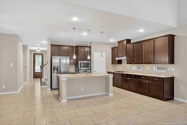 a large kitchen with stainless steel appliances lots of counter top space