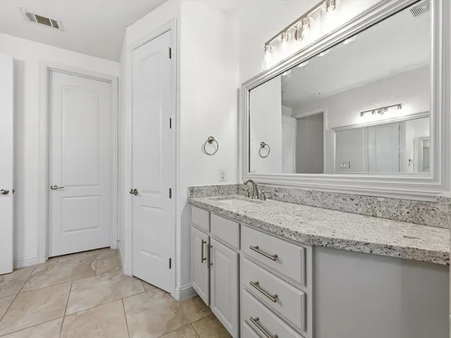 a bathroom with a granite countertop sink and a mirror