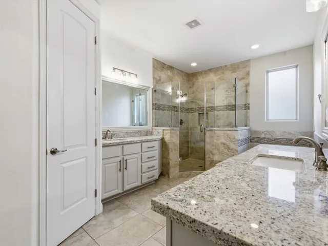 a bathroom with a granite countertop sink a mirror and a shower