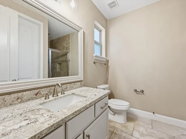 a bathroom with a granite countertop sink toilet and shower
