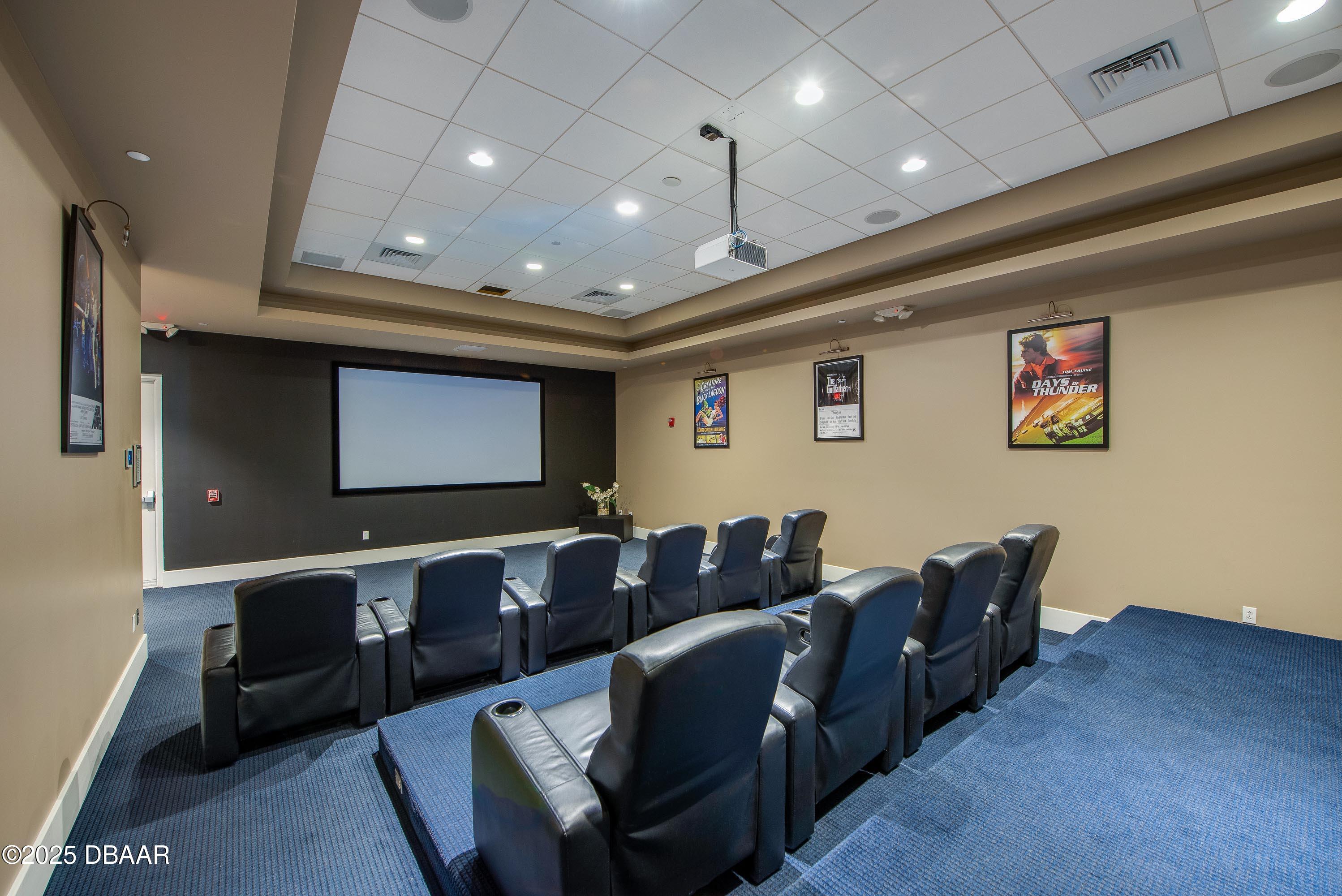 241 Riverside Drive, Unit 2603 Holly Hill, FL 32117 - Photo 12 of 71 a media room with lots of chairs and a projector screen