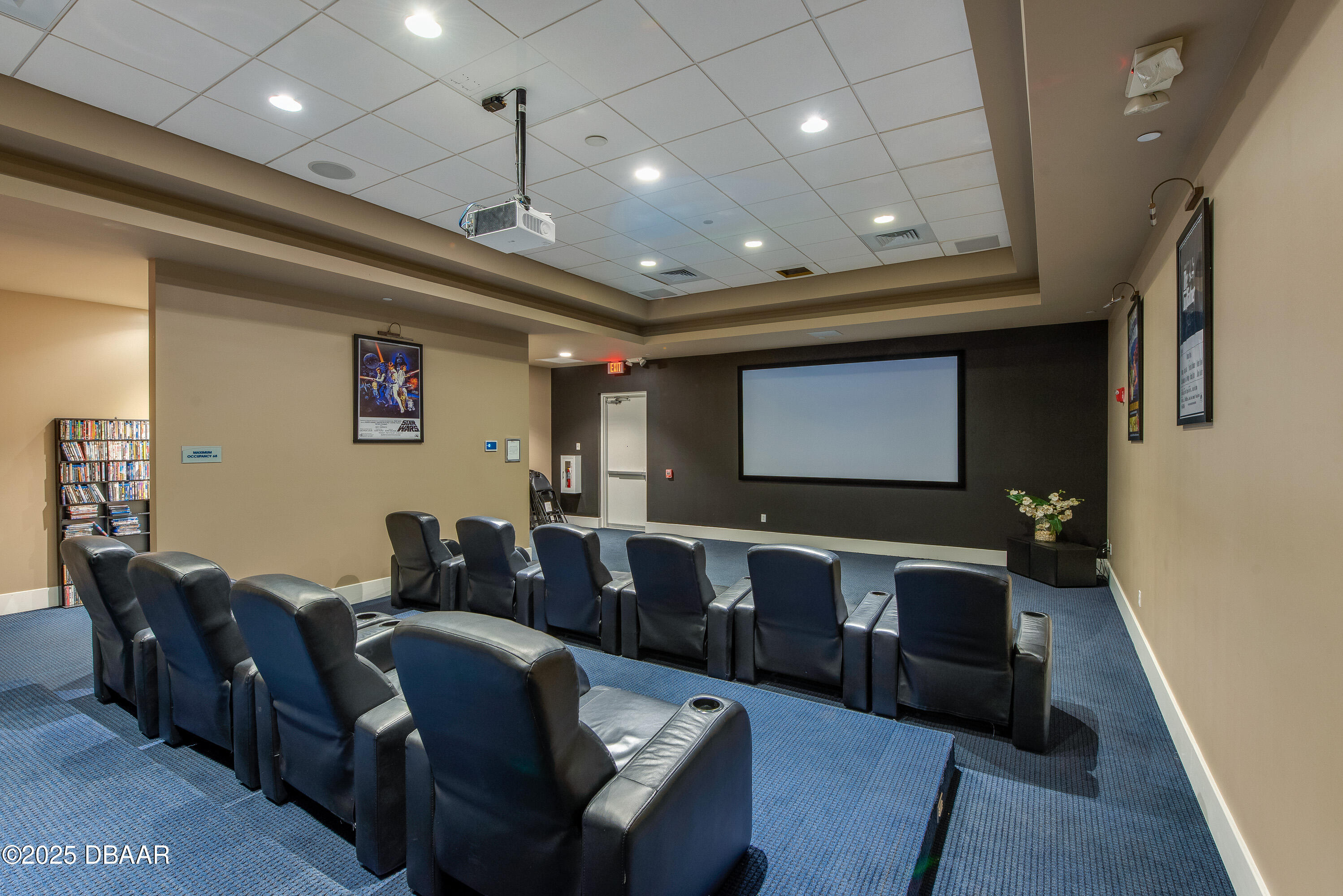 241 Riverside Drive, Unit 2603 Holly Hill, FL 32117 - Photo 13 of 71 a media room with lots of chairs and a projector screen
