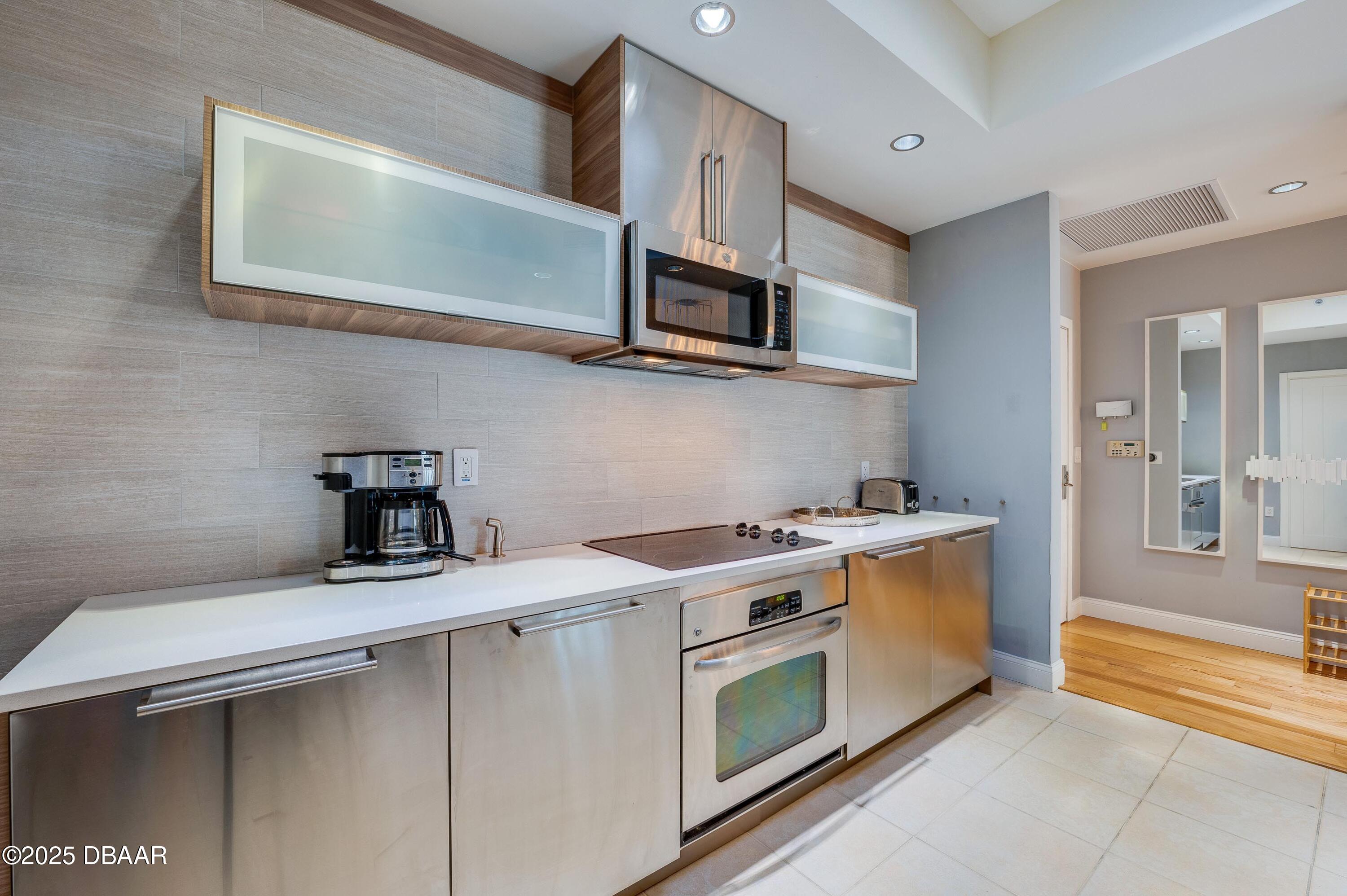 241 Riverside Drive, Unit 2603 Holly Hill, FL 32117 - Photo 21 of 71 a kitchen with stainless steel appliances granite countertop a sink a stove and a microwave