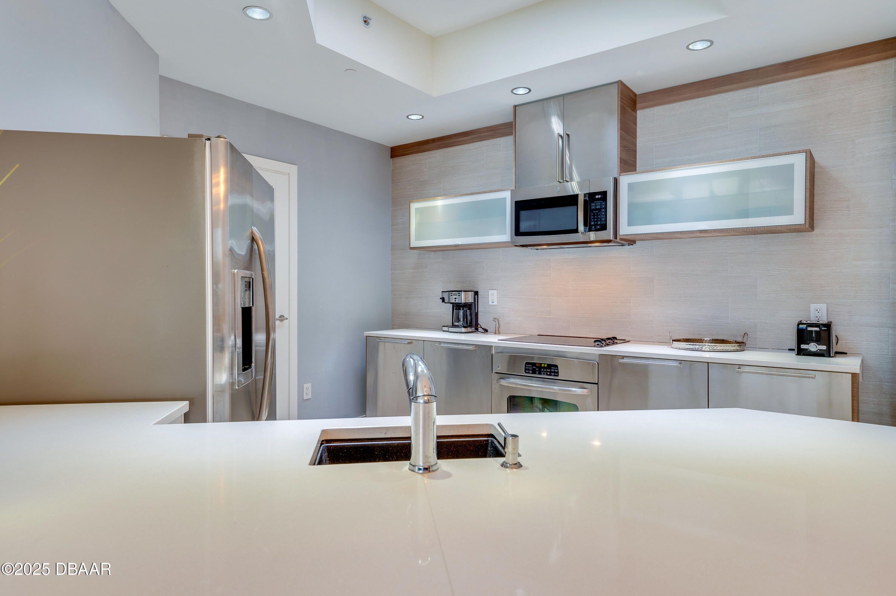 241 Riverside Drive, Unit 2603 Holly Hill, FL 32117 - Photo 27 of 71 a kitchen with stainless steel appliances white cabinets and a refrigerator