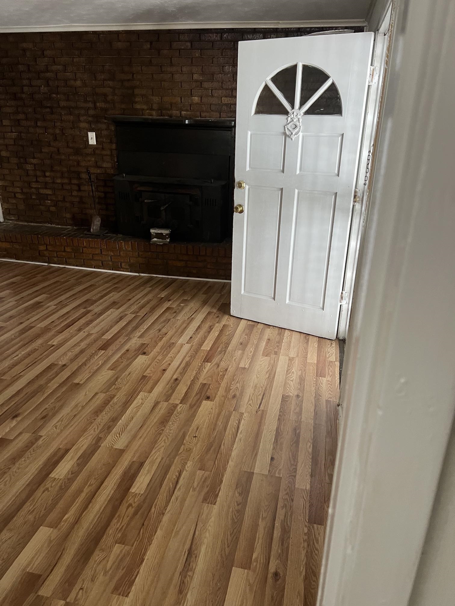 518 Harris Street Collierville, TN 38017 - Photo 9 of 13 Exposed brick wall featuring a built-in hearth and dark-toned wood stove