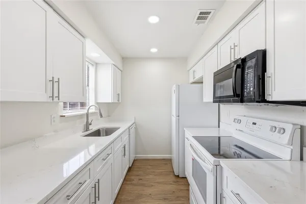 a kitchen with stainless steel appliances granite countertop a sink and a microwave