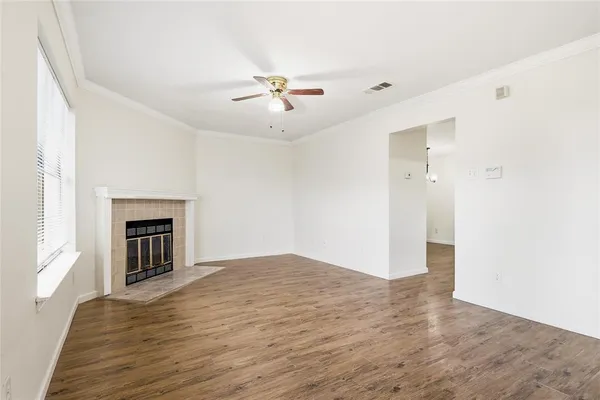 a view of empty room with wooden floor and fireplace