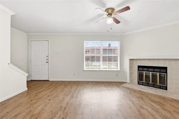 a view of wooden floor fire place refrigerator and window in a room