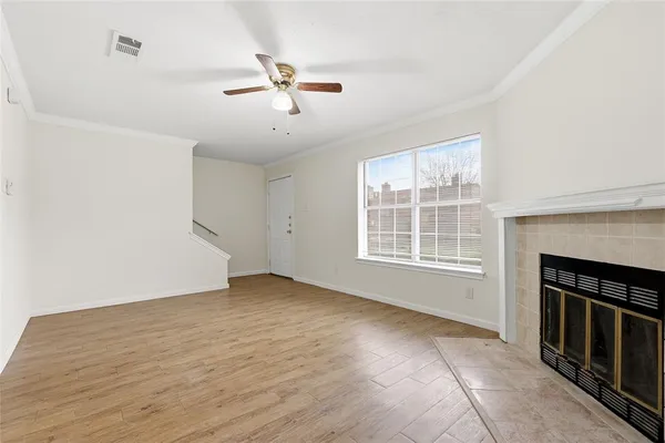 an empty room with windows cabinet and fireplace
