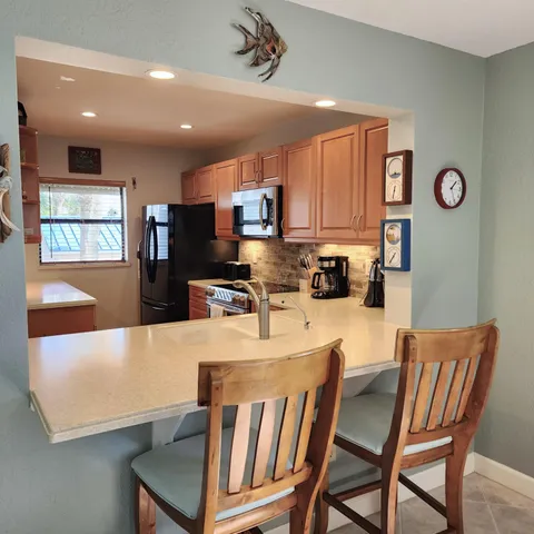 a living room with stainless steel appliances a dining table and chairs