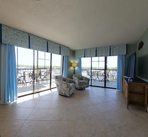 a living room with furniture and large windows