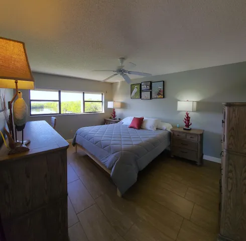 a bedroom with a bed a lamp and a window