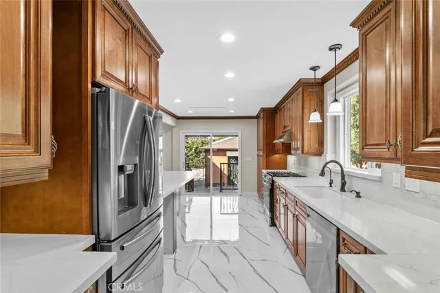 a kitchen with stainless steel appliances granite countertop a refrigerator and a sink