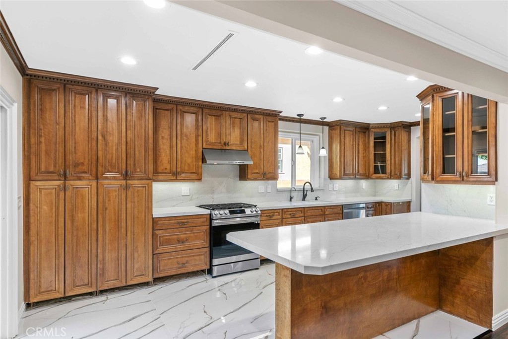 415 Birmingham Road Burbank, CA 91504 - Photo 18 of 61 a kitchen with a sink stainless steel appliances granite countertop wooden cabinets and sink
