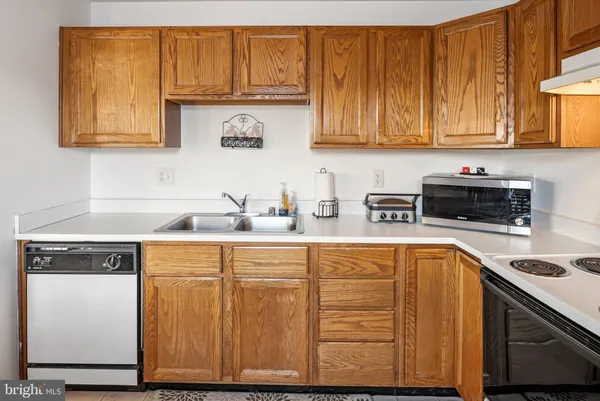 a kitchen with stainless steel appliances granite countertop wooden cabinets a sink and dishwasher