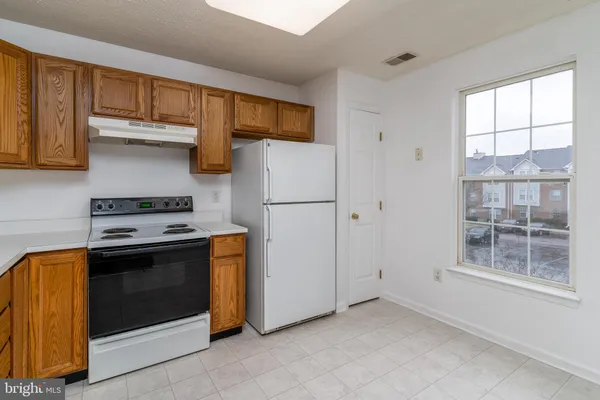a kitchen with stainless steel appliances granite countertop a refrigerator and a stove