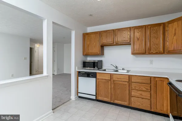 a kitchen with stainless steel appliances granite countertop a sink and cabinets with wooden floor
