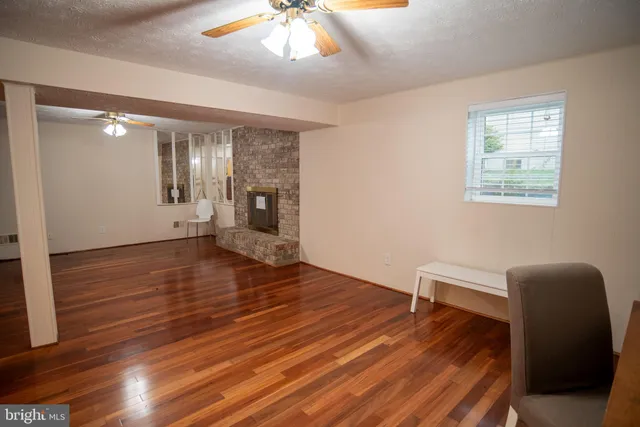 a view of an empty room with wooden floor and staircase