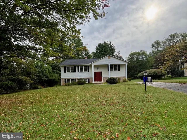 a front view of a house with a garden and trees