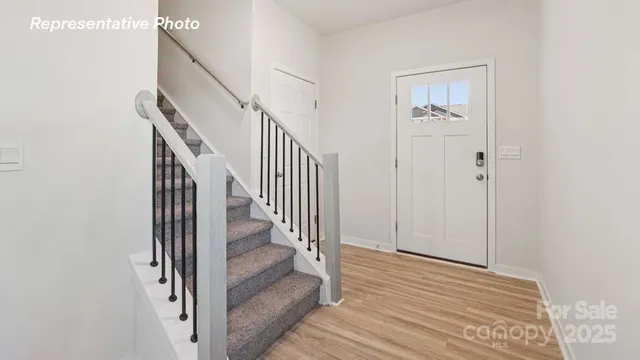 a view of a hallway with wooden floor and entryway