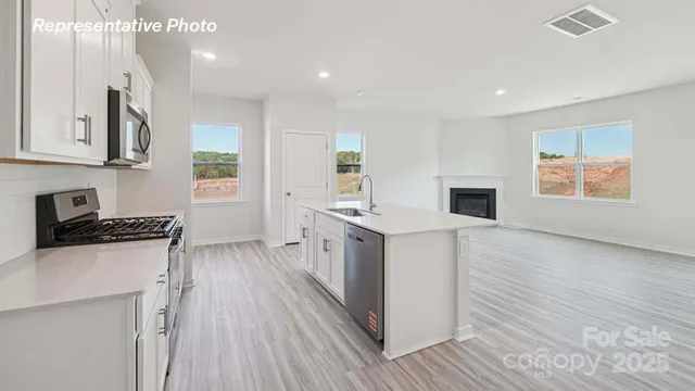 a kitchen with granite countertop a sink stove and cabinets