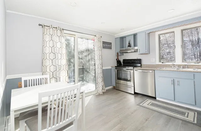 a kitchen with granite countertop a stove a sink and a refrigerator