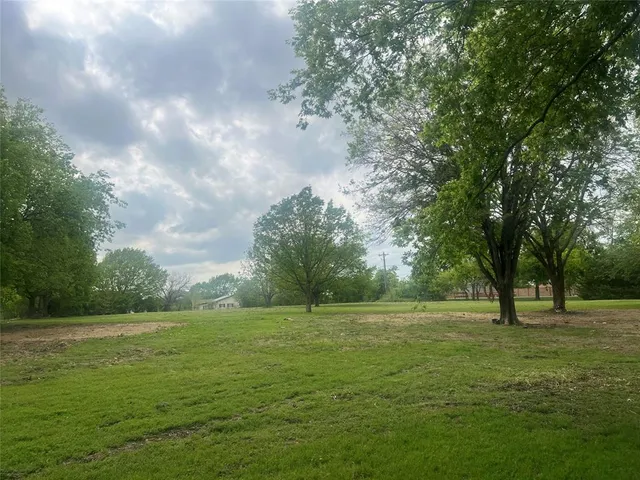 a view of outdoor space with green field and trees all around