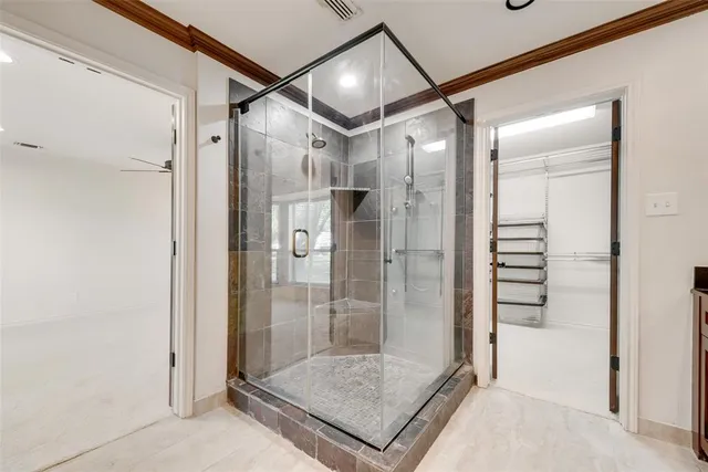 a bathroom with a shower and a glass door