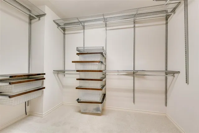 a view of walk in closet with empty racks