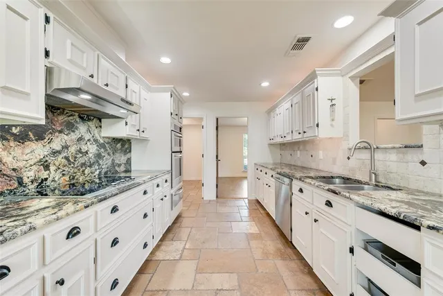 a large kitchen with stainless steel appliances granite countertop a stove and a sink