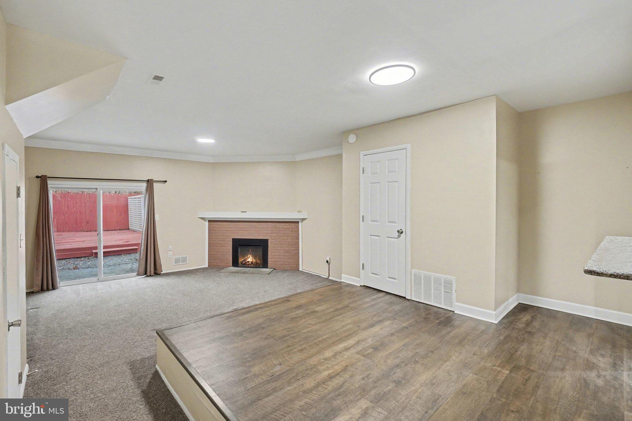 a view of a livingroom with an empty space and a fireplace