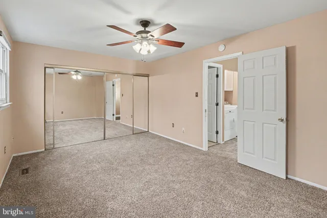 a view of an empty room and a ceiling fan