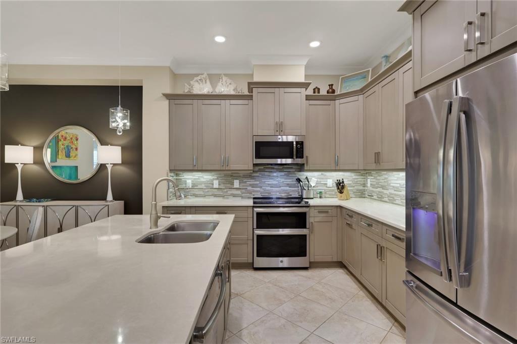 5752 Elbow Avenue Naples, FL 34113 - Photo 8 of 38 Kitchen featuring stainless steel appliances, light stone counters, decorative light fixtures, decorative backsplash, and light tile patterned floors