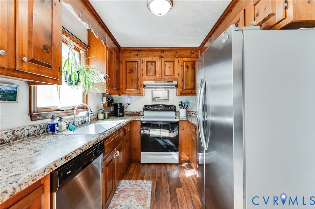 445 Poplar Road Aylett, VA 23009 - Photo 14 of 36 a kitchen with granite countertop a refrigerator a sink dishwasher with wooden cabinets and floor