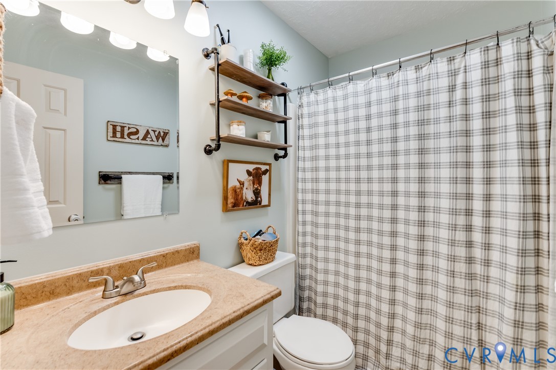 445 Poplar Road Aylett, VA 23009 - Photo 21 of 36 a bathroom with a sink a toilet and shower curtain