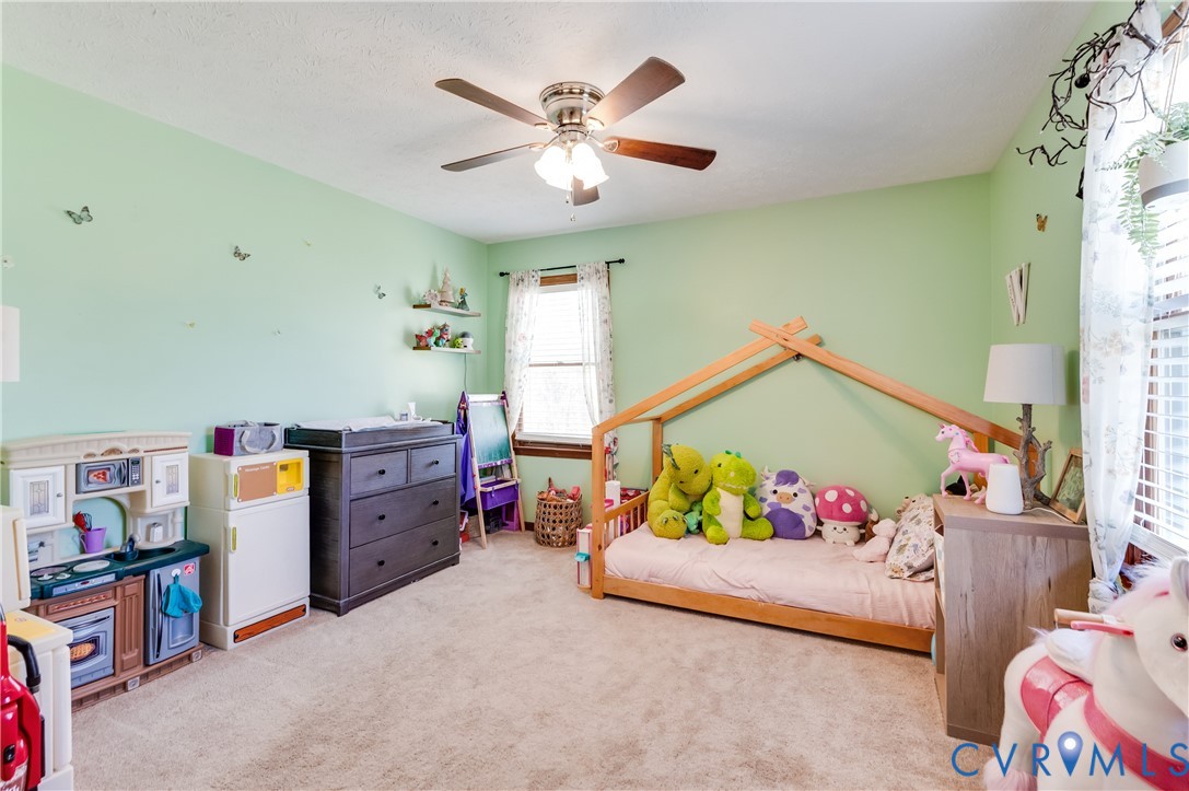 445 Poplar Road Aylett, VA 23009 - Photo 23 of 36 a bedroom with a bed and a chandelier
