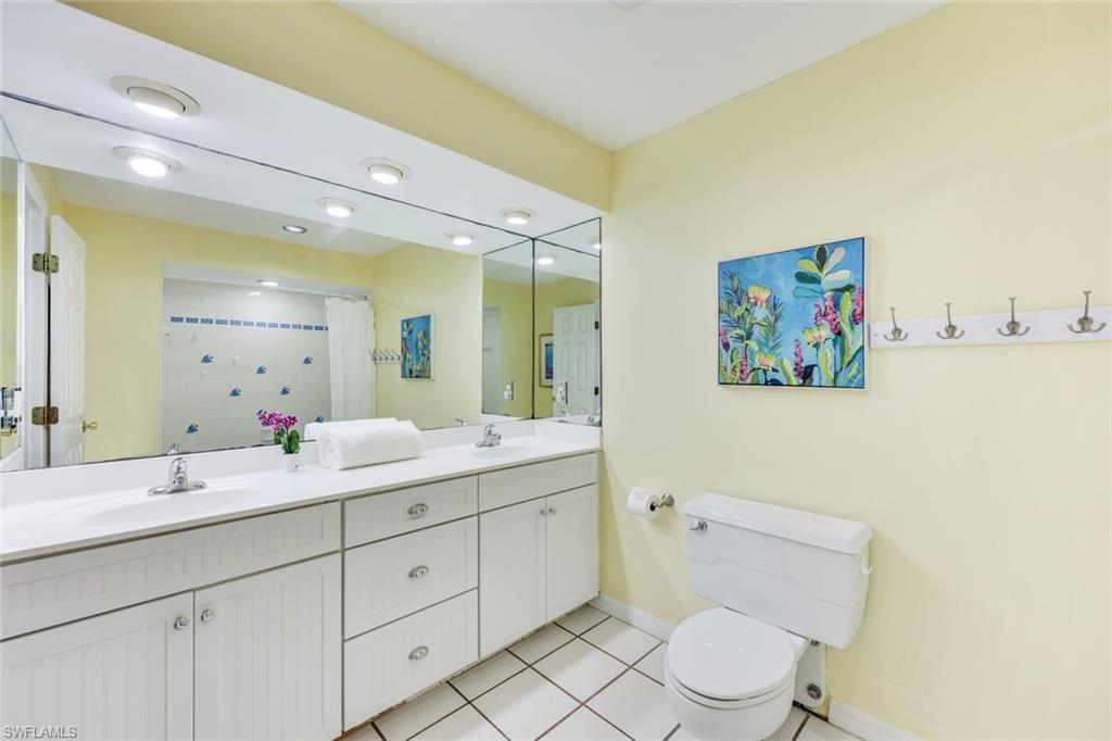131 Cajeput Drive Naples, FL 34108 - Photo 15 of 30 a bathroom with a toilet a sink a mirror and a shower