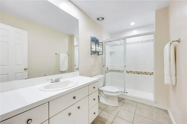 a bathroom with a double vanity sink toilet mirror and shower