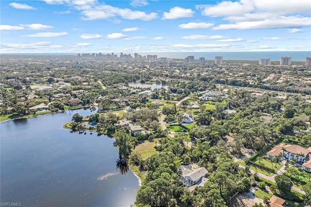 an aerial view of residential houses with outdoor space and trees