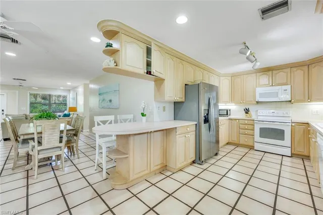a kitchen with cabinets and chairs